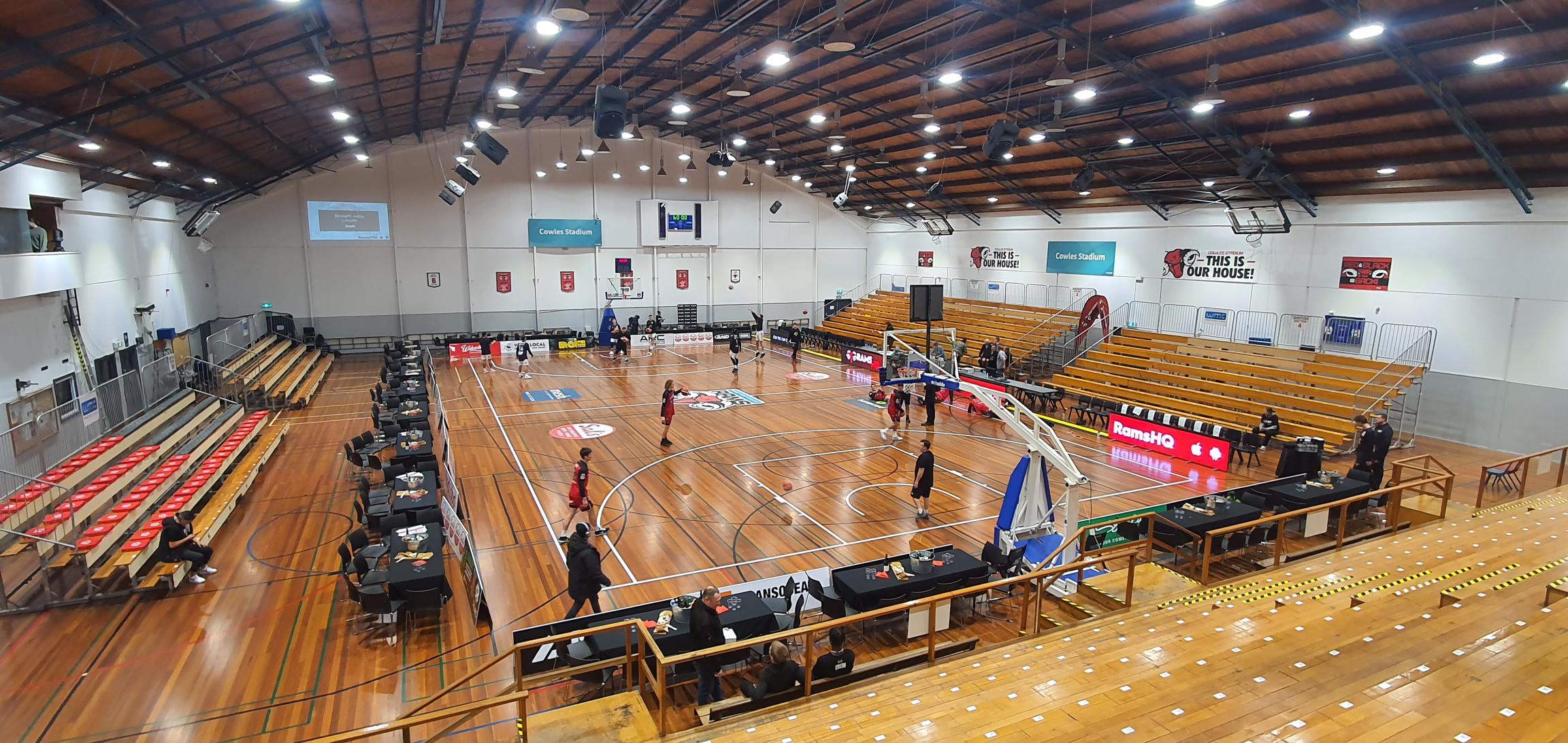 Cowles stadium court set up for a basketball game with players warming up on the court. 