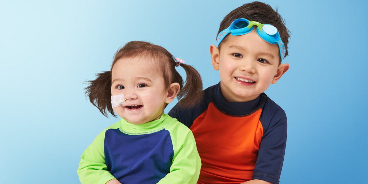 Two smiling children in swimmers and goggles. 