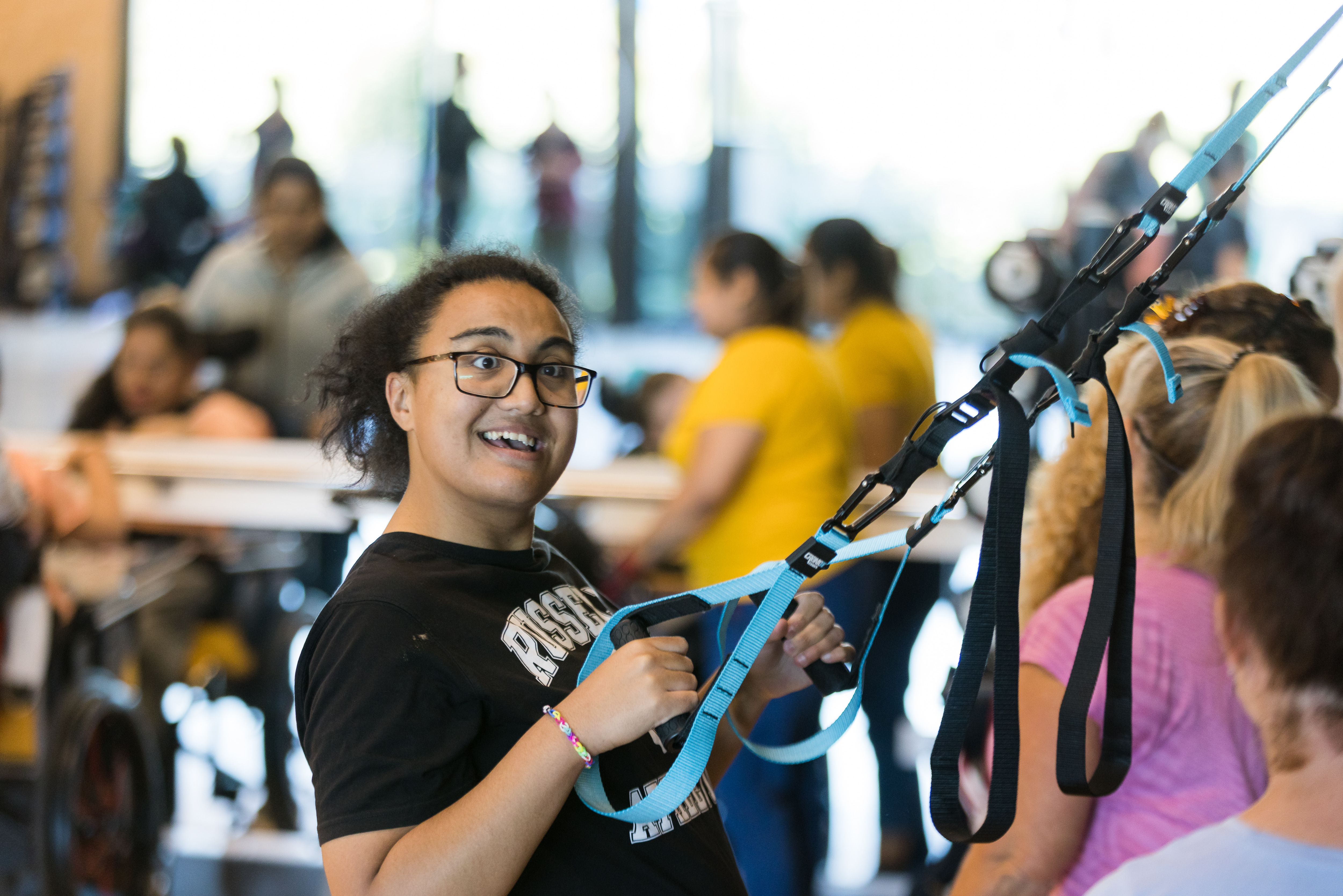 A smiling young woman participating in a FUNky Movements group fitness class for disabled people in Christchurch 