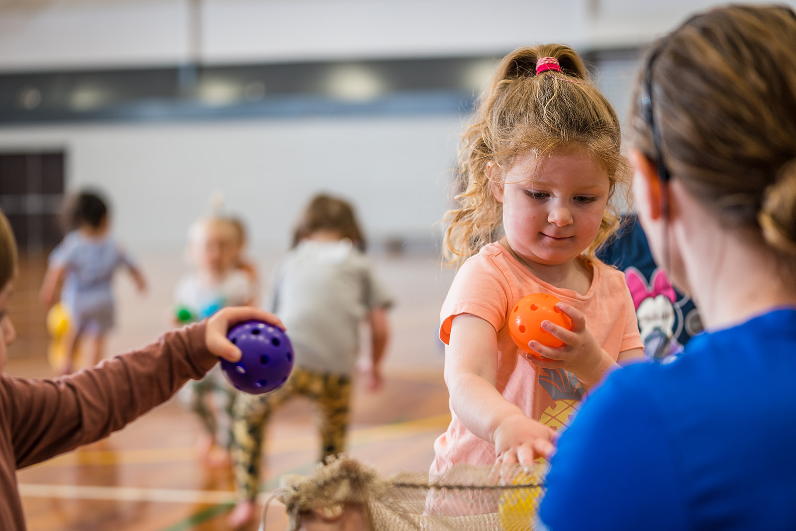 A group of toddlers holding onto multicoloured balls during a Tumbletimes class at Christchurch Recreation and Sport Centre.