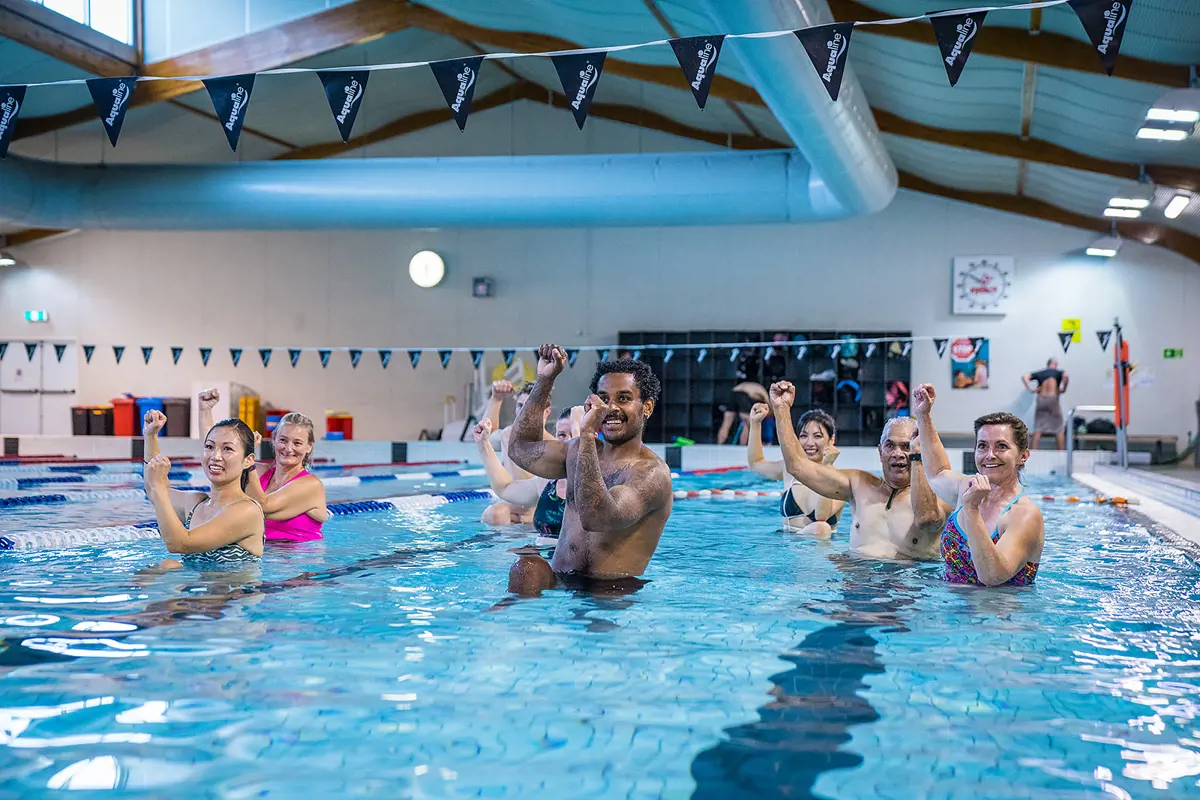 A group of men and women participating in an Aqua class at Christchurch Recreation and Sport pool.