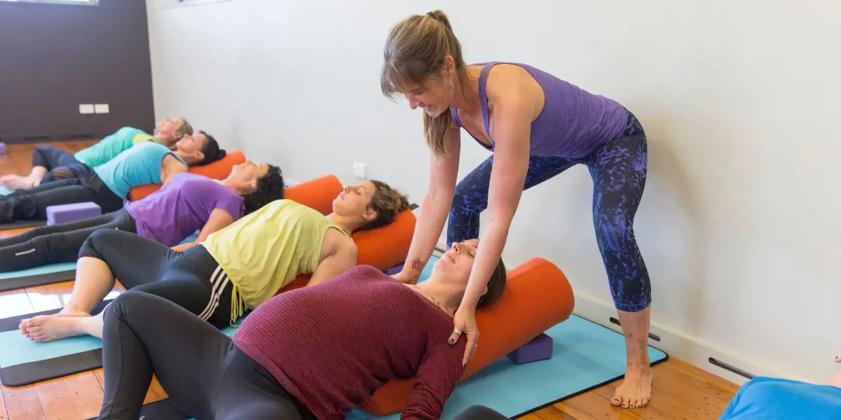 An instructor helping a woman stretch during a Rest and Restore class at Christchurch Recreation and Sport centre.